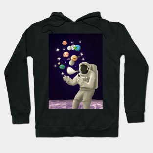 An astronaut on the moon plays with the planets like soap bubbles Hoodie